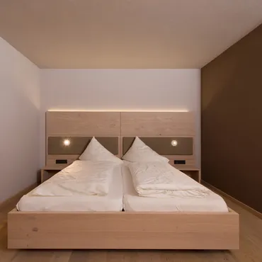 Hammerspitze Modernes Hotelzimmer mit Doppelbett, Holzmöbeln und minimalistischem Design